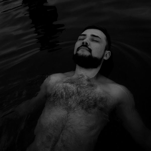 Person meditating peacefully in a calm, natural environment.