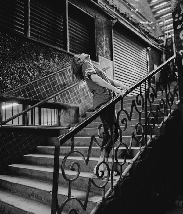 Woman in a dynamic cardio pose in a modern, dimly lit studio.